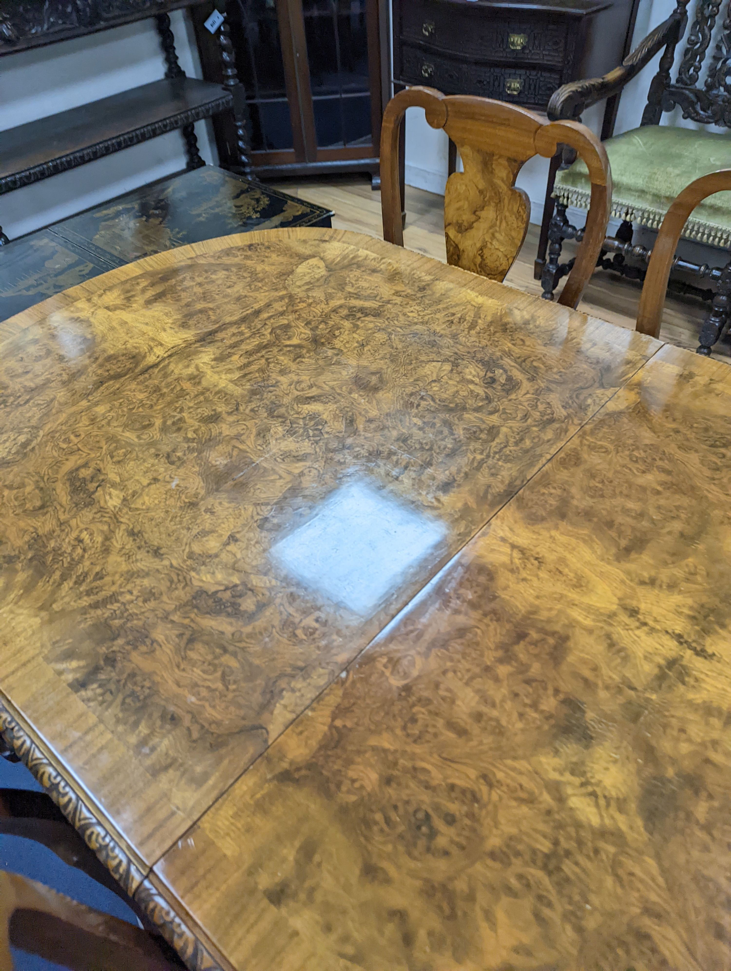 A Queen Anne revival burr walnut dining suite, comprising serpentine sideboard, length 168cm, depth 56cm, height 98cm, extending dining table, 210cm extended, one spare leaf, width 90cm, height 75cm and eight chairs, two